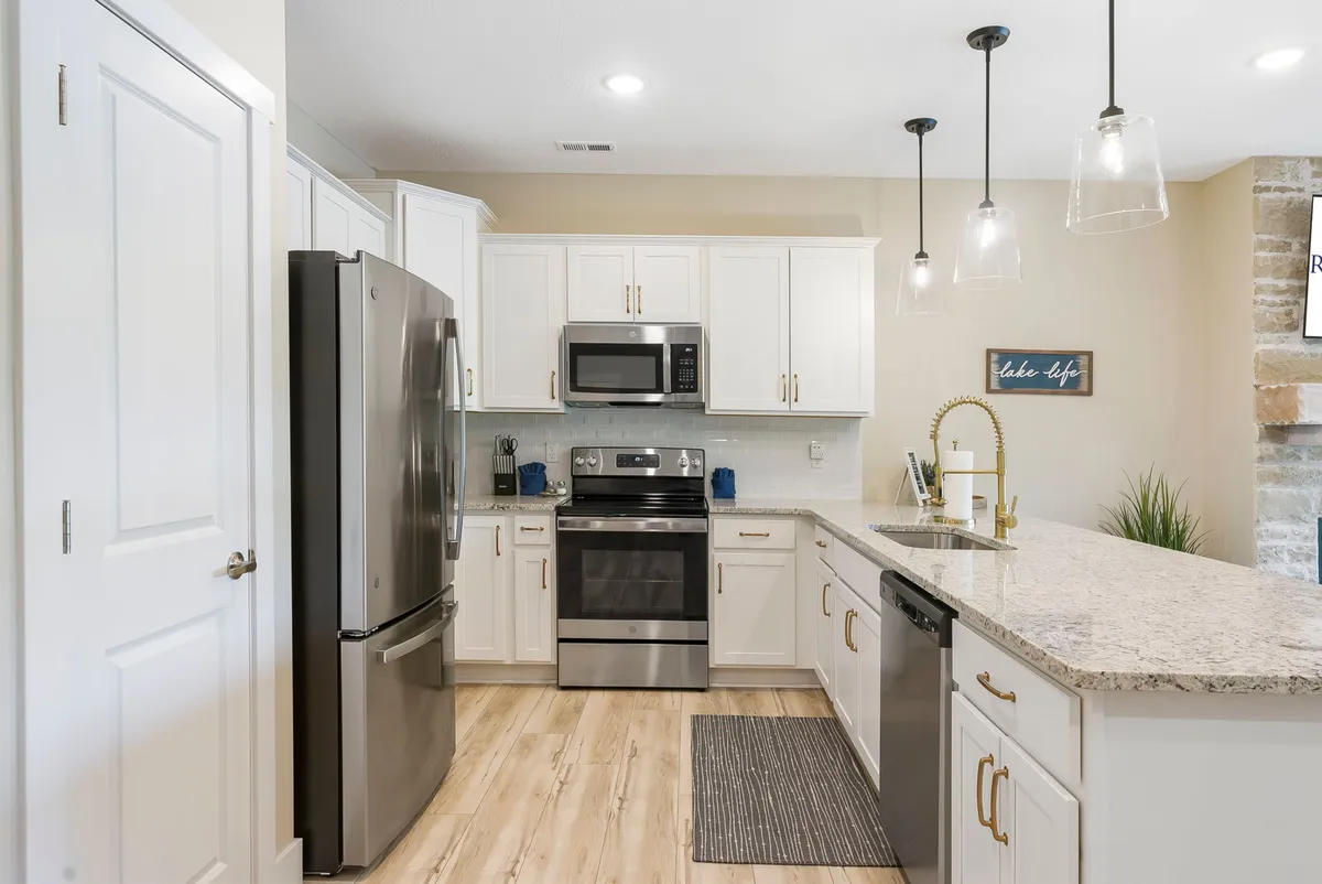 A stylish, open-concept kitchen with stainless steel appliances, granite countertops, and pendant lighting. The layout invites gourmet meal preparation and social gatherings, echoing the content about creating special dinners inside.